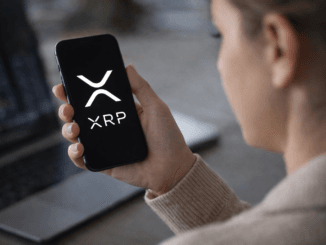 Person holding a smartphone displaying the XRP cryptocurrency logo while checking digital asset markets.